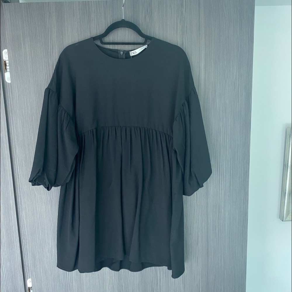 Black smock dress with puff sleeves, empire waist.